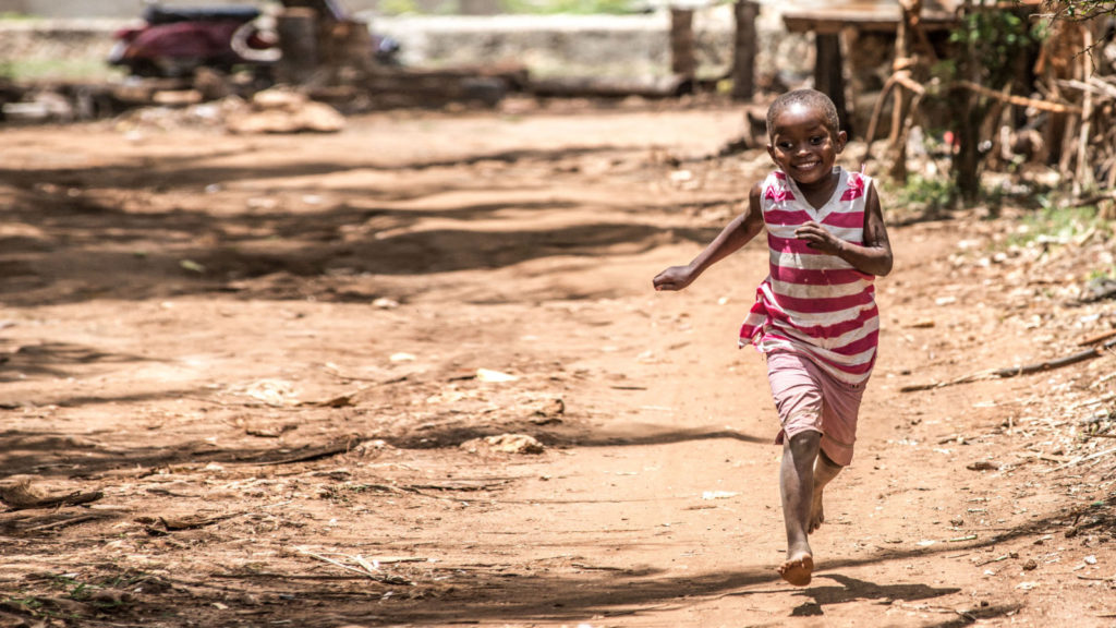 Asha runs down the road outside her home in Zanzibar days after a successful bilateral cataract operation.