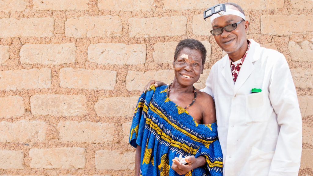 Diokoura standing with the trachoma surgeon, Modibo Sanogo, in Mali.