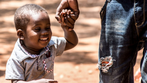 Bakir Rashid, 2, smiles as he walks with his father on a family outing to the beach days after a successful bilateral cataract operation.