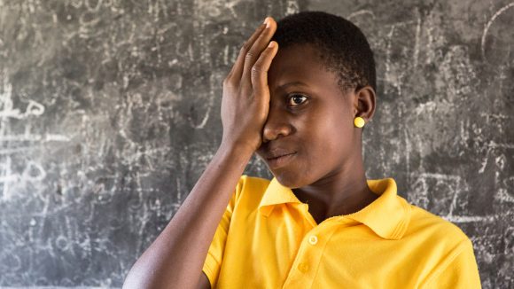 A girl covers her eye with one hand during a sight test at a school on Ghana.