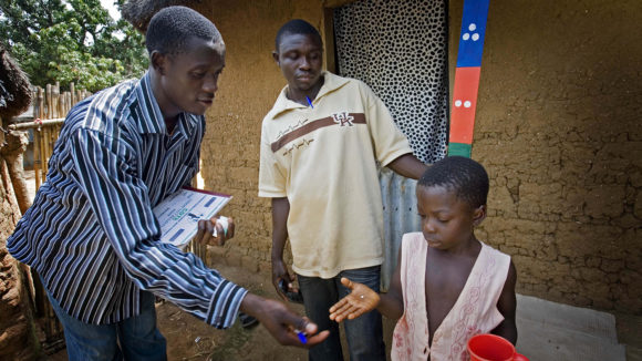 A drug distributor gives out medication to protect against river blindness and lymphatic filariasis.