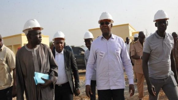 Il Ministro dell'istruzione del Senegal è accampagnato da ispettori sul cantiere di una residenza per studenti, portano il casco di protezione