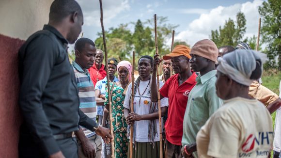 Volunteer community drug distributors are shown how to use measuring sticks to calculate drug dosages.