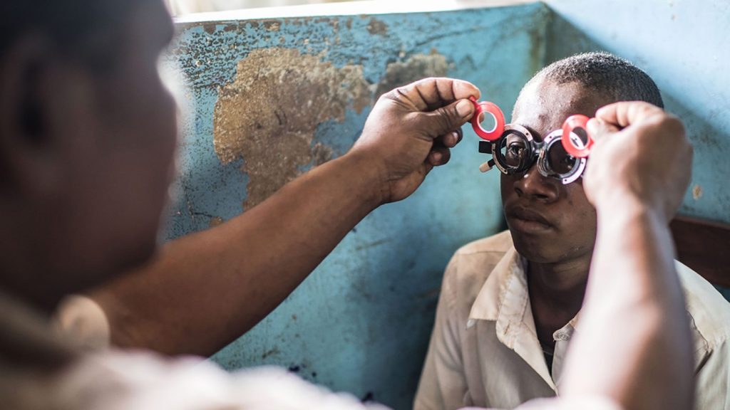 A boy has his eyes tested for refractive error.
