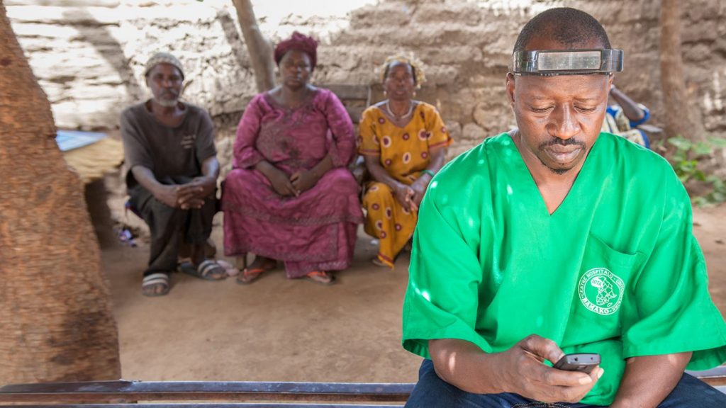 Mobile surgeon Boubacar Fomba checks his mobile phone.