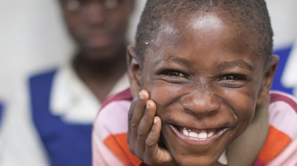 A boy grins at the camera.