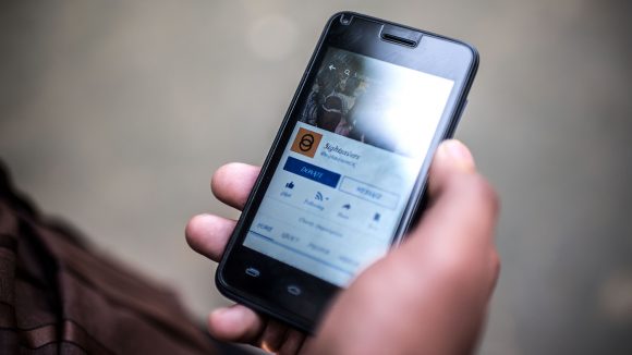 A mobile phone showing Sightsavers' Facebook page.