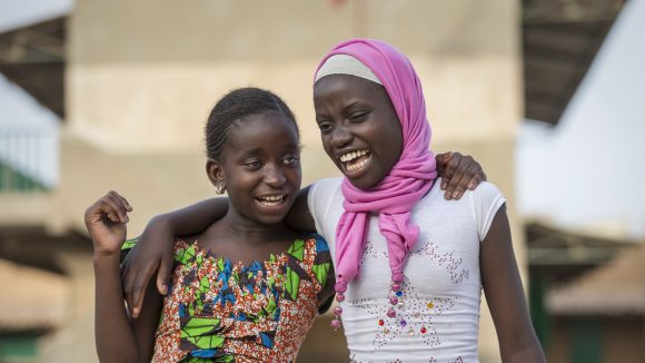 Due bambine sorridenti si abbracciano