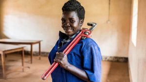 Una donna tiene in mano delle stampelle rosse.