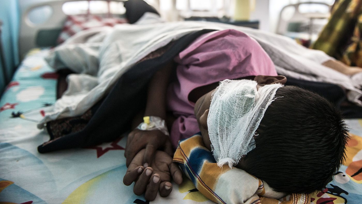 Un bambino sta dormendo su un lettino dell'ospedale con una benda sull'occhio destro.
