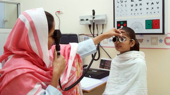 Una bambina viene sottoposta ad una visita oculistica da una dottoressa