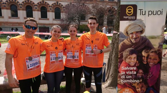 Quattro ragazzi con le pettorine di Sightsavers dopo la maratona di Milano