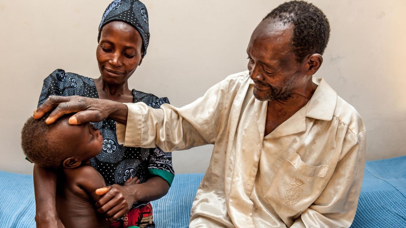 Winesi vede il suo nipotino per la prima volta. Accanto a lui seduti ci sono sua figlia e in braccio il suo bambino.