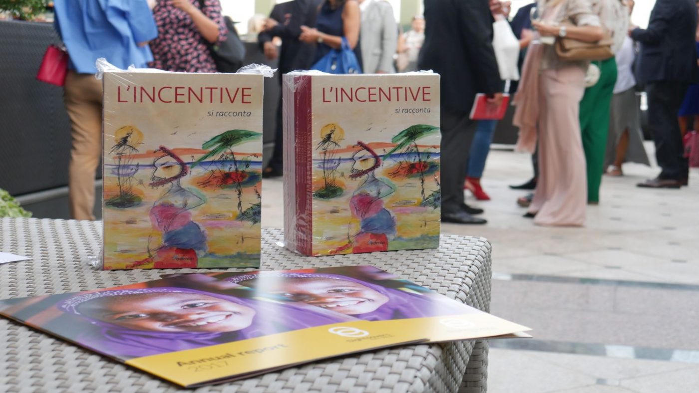 Al primo piano ci sono delle brochure di Sightsavers e degli esemplari del libro, dietro delle persone stanno parlando tra di loro