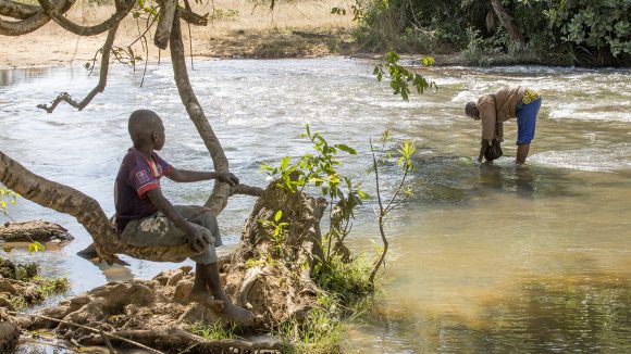 Due uomini stanno catturando delle mosche in un fiume che scorre velocemente