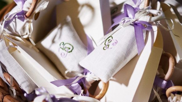 cestino con delle scatoline portaconfetti e dei sacchetini colorati per un matrimonio