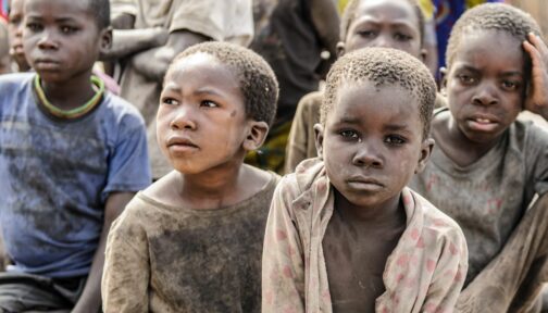 Bambini malati di tracoma e sporchi di polvere guardano davanti a se.
