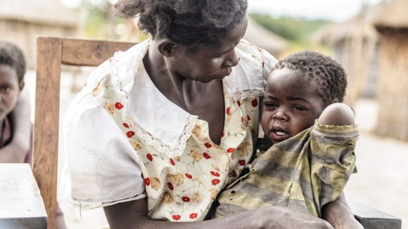 Una bambina piange tra le braccia della sua mamma.