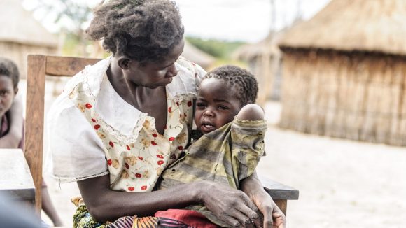 Una bambina piange tra le braccia della sua mamma.