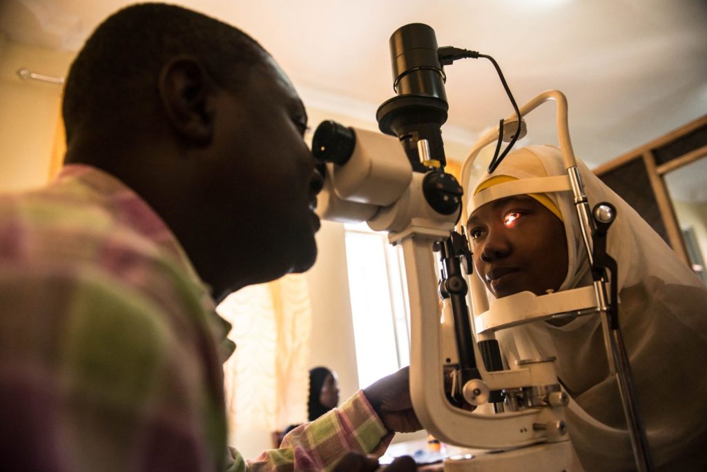 Dr Paul Nyaluke examines a person's eyes.