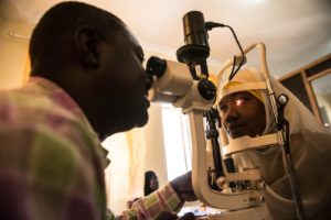 Dr Paul Nyaluke examines a person's eyes.