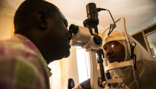 Dr Paul Nyaluke examines a person's eyes.