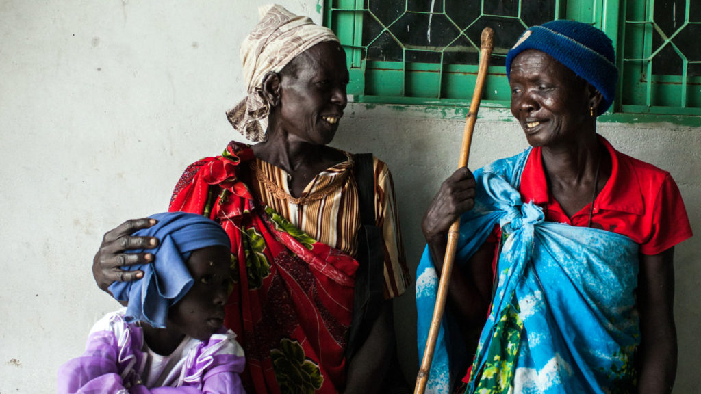 Photo of Nyakaka Yaul Nyuon, 50, who had cataract surgery on her right eye, looks at her twin sister Julius Yaul, and niece Nyakong in Nasir, Upper Nile, South Sudan,