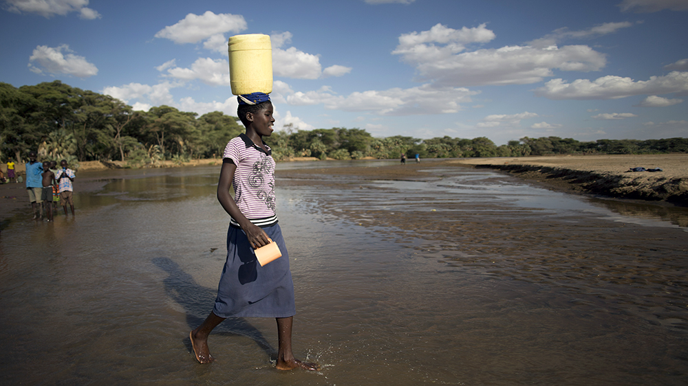 A girl carries water she collected in Turkana, northern Kenya.