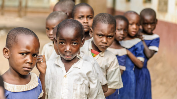 Dei bambini in fila davanti alla loro scuola in Tanzania.