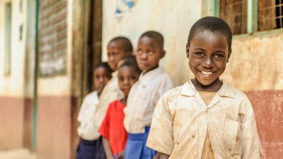 Zuhura dalla Tanzania in posa davanti alla sua scuola primaria.