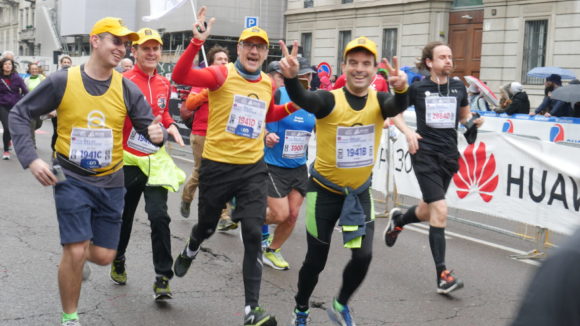 Quattro maratoneti maschi stanno correndo verso l'arrivo della maratona