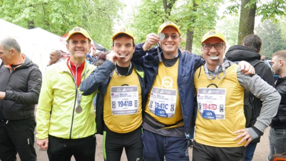 Quattro maratoneti mostrano la medaglia dopo la maratona