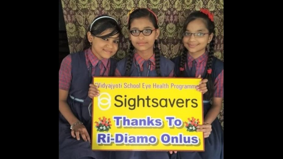 Tre ragazzine tengono in mano un cartello per ringraziare Ri-diamo.