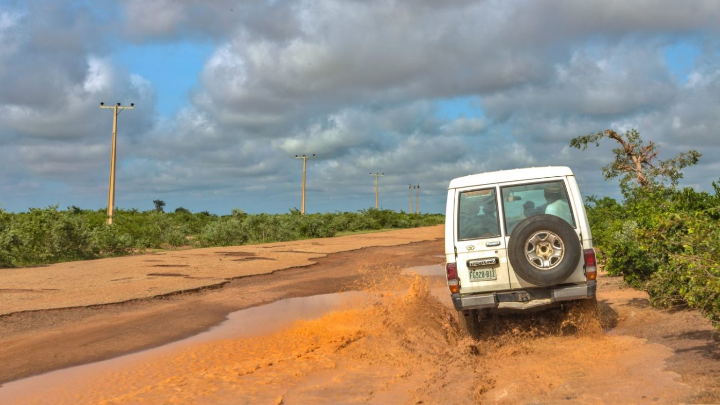 Una jeep bianca su una strada sterrata e fangosa.