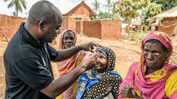 An eye surgeon examines a woman's eyes to check for signs of trachoma.