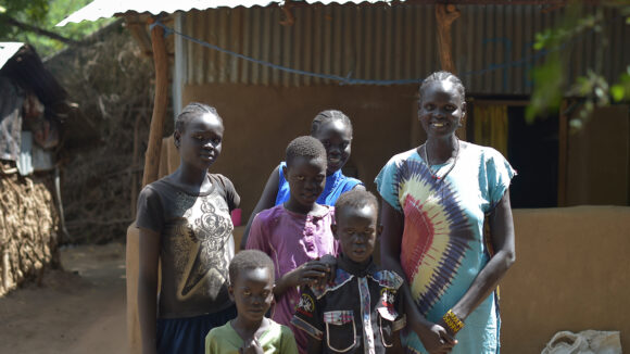 Rebecca stands alongside her five children in front of a building in Northern Kenya.