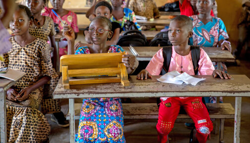Children sit in a classroom.