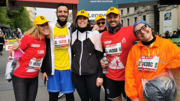 Cinque maratoneti sorridono dopo aver corso.