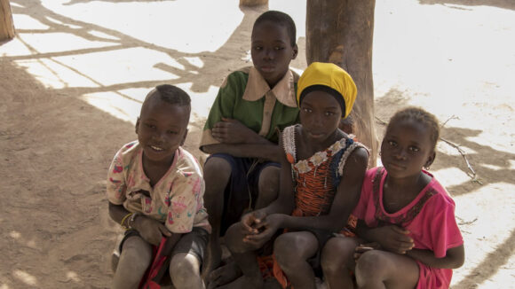 Bambini seduti sulla terra in Mali.