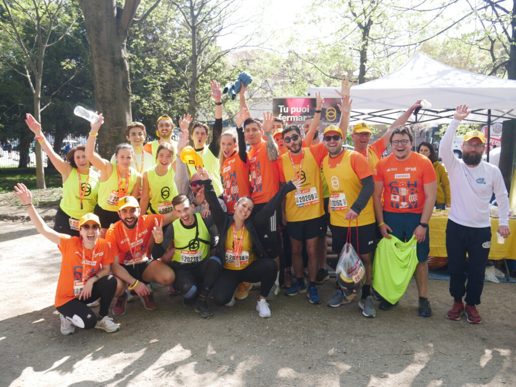 Una ventina di runner stanno salutando davanti allo stand di Sightsavers durante la maratona