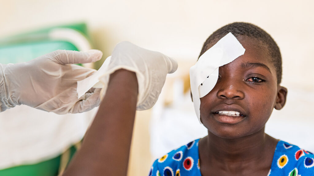 Mary dal Malawi rimuove le bende dopo l'operazione di cataratta.