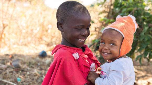 Ebenezeri e suo fratello sorridono abbracciati.