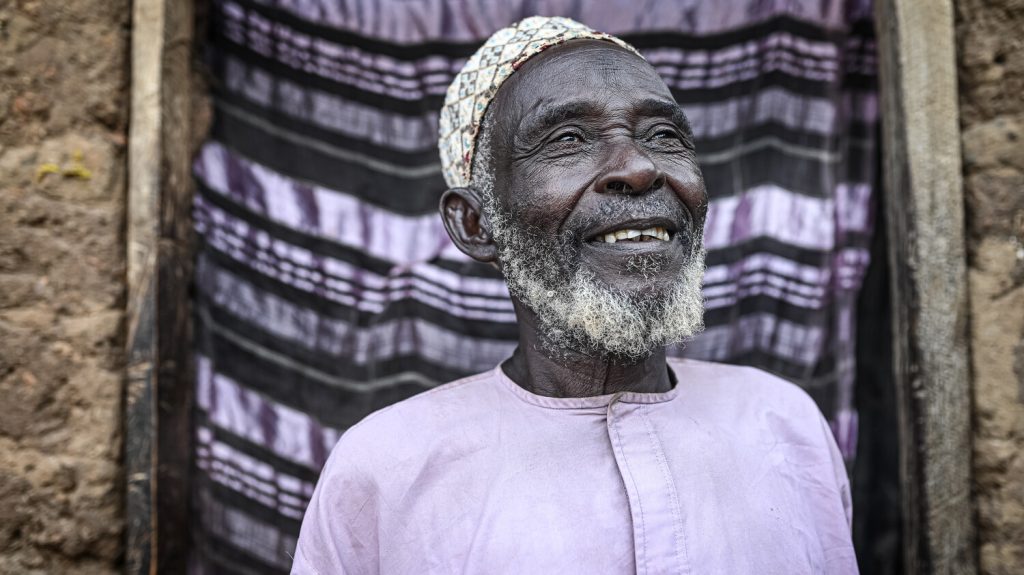Alhaji Ado Audu, agricoltore del villaggio di Kudaru in Nigeria, in primo piano.