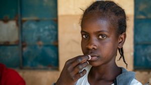 Una bambina prende la medicina contro i vermi intestinali.